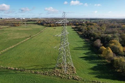 High voltage post,High voltage tower sky field grass housing esate aerial dro Foto stock