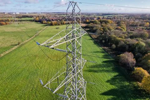 High voltage post,High voltage tower sky field grass housing esate aerial dro Foto stock