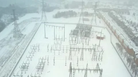 High voltage power grid station at winter storm. Pylons and high voltage tr.. Stock Footage 268617588