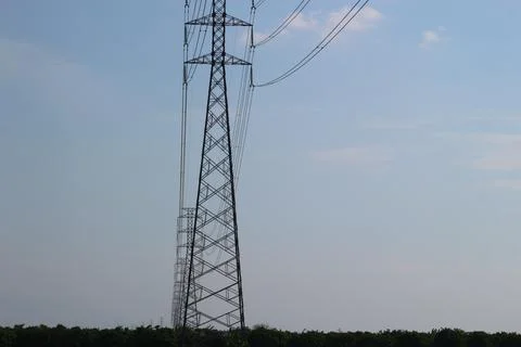 High-voltage power grid tower model across rice fields Stock Photos