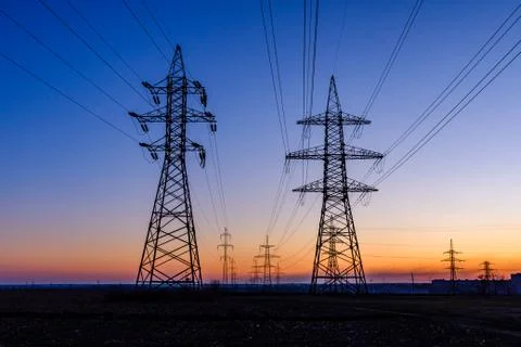 High voltage power line in a field at sunset Stock Photos