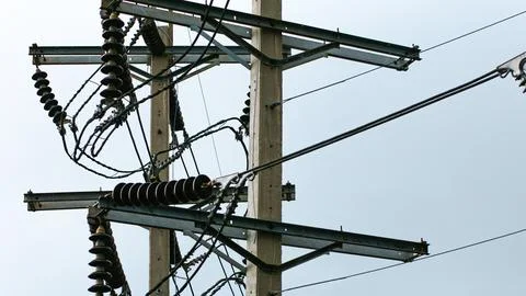 High Voltage Power Line Insulators Silhouetted Against Overcast Sky 写真素材