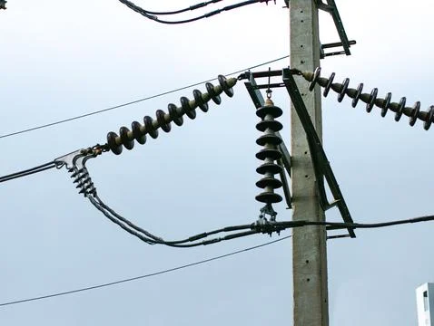 High Voltage Power Line Insulators Silhouetted Against Overcast Sky Stock Photos