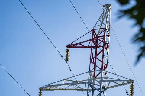 High voltage power line pylon against blue sky Foto stock