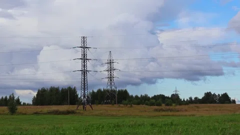High voltage power line pylons in the field and blue sky with clouds Stock Footage 283004044