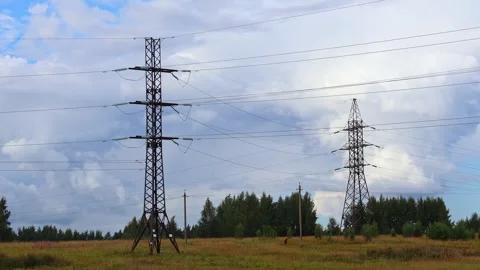 High voltage power line pylons in the field and blue sky with clouds Stock Footage 283004200