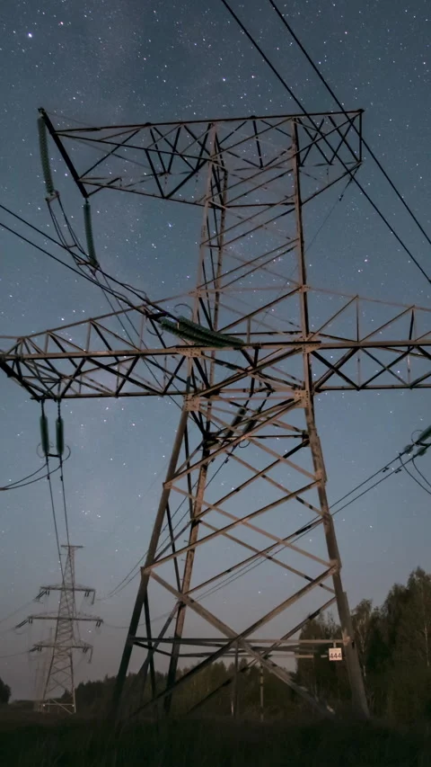 High voltage power line tower under starry night sky time lapse Stock Footage 346033791