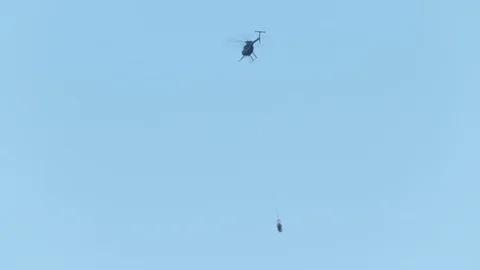 High Voltage Power Lineman hanging from a helicopter Stock Footage 127219916