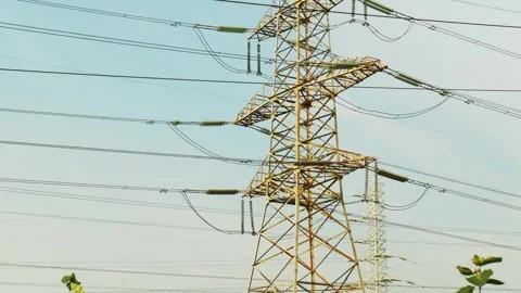 High-voltage power lines and tall towers standing firmly under the clear blue Stock Footage 315339849