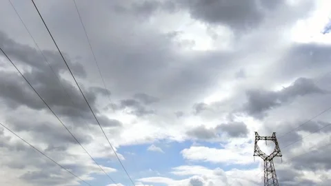 High Voltage Power Lines and Electricity Pylon Under Moving Clouds in Blue Sky Stock Footage 341959736