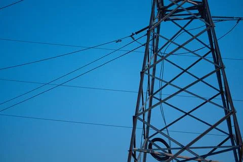 High Voltage Power Lines and Electricity Pylon Against Blue Sky Stock Photos