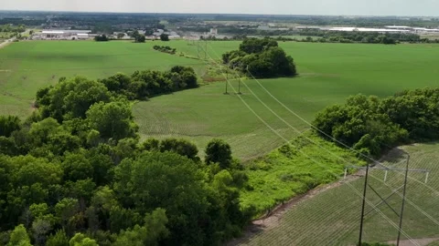 High Voltage Power Lines Over Green Farm Fields Stock Footage 338366151