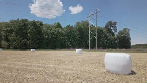 High-voltage power lines pass through a recently harvested wheat field with Stockbeeldmateriaal 337181719