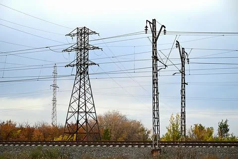 High-voltage power lines passing through a plowed field, on the background of Stock Photos