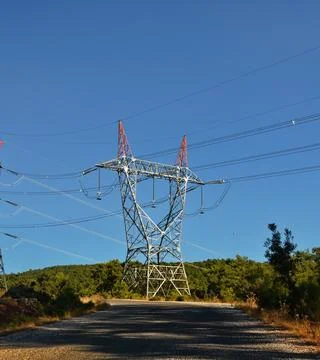 High-voltage power lines passing through a plowed field, on the background of Stock Photos