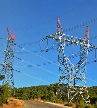 High-voltage power lines passing through a plowed field, on the background of Stock Photos