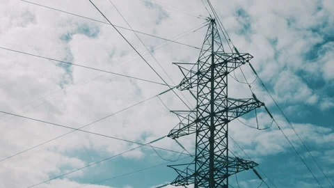 High Voltage Power Lines Standing Tall Against a Dramatic Cloudy Sky Forming a S Stock Footage 318182340