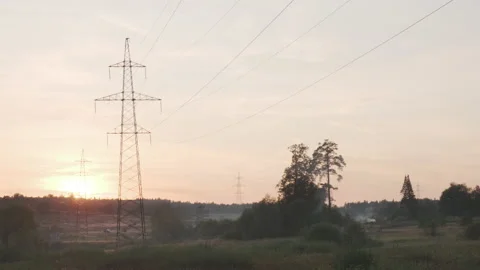 High-voltage power lines at sunset at summer. Backlight summer shot with smoke Stock Footage 148787581