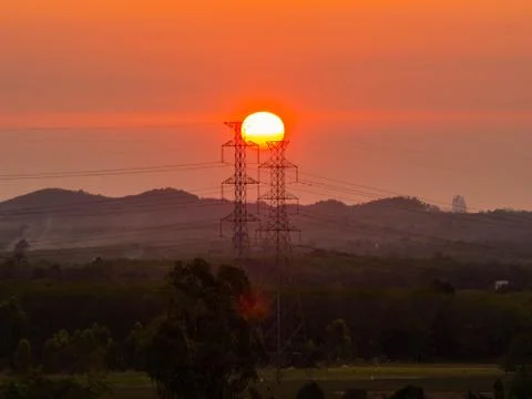 High-voltage power lines at sunset or sunrise. Distribution electric substati Stock Photos