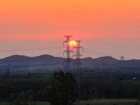 High-voltage power lines at sunset or sunrise. Distribution electric substati Stock Photos