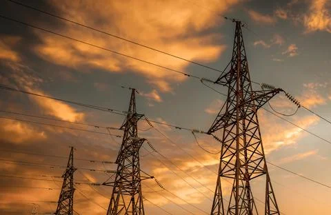 High voltage power lines at sunset. Electricity is dangerous Stock Photos