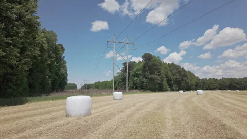 High-voltage power lines tower over a recently harvested wheat field with Stockbeeldmateriaal 337181850
