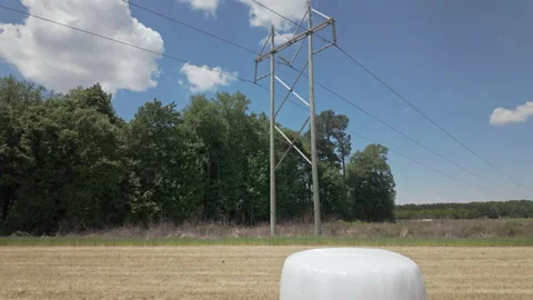 High-voltage power lines tower over a recently harvested wheat field with Stockbeeldmateriaal 337181932