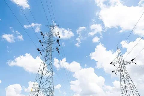 High voltage power lines under a blue sky with clouds Stock Photos