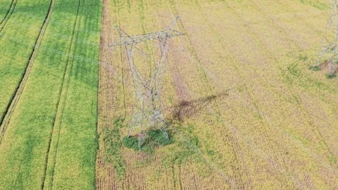 High-voltage power pole among farmland. Drone footage. Video stock 331826932