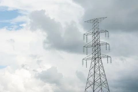 High voltage power pole close against evening sky. Stock Photos