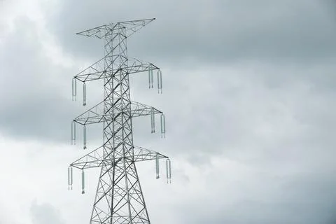 High voltage power pole close against evening sky. Stock Photos