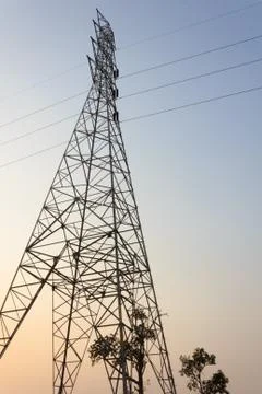 High voltage power pole middle of a cornfield at sunset. Stock Photos