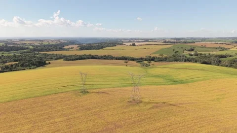 High-voltage power poles among beautiful farmland. Drone footage. Stock Footage 331826972