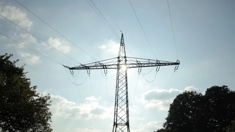 High voltage power pylons close up on against the sun. Silhouette pan shot Stock Footage 86219252