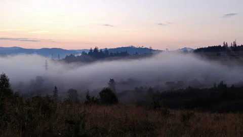 High voltage power pylons in misty mountain valley at dawn landscape Stock Footage 340462564