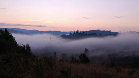 High voltage power pylons in misty mountain valley at dawn landscape Stock Footage 340462569