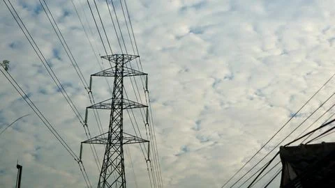 High voltage power tower against a patterned cloudy sky Stock Photos