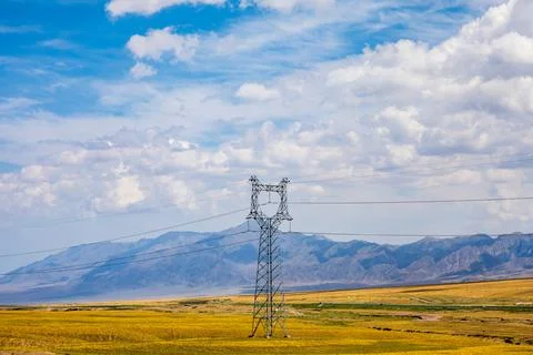 High voltage power tower and beautiful mountain scenery in Xinjiang. Stock Photos