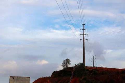 High Voltage Pylon on Hillside under Overcast Sky Фото