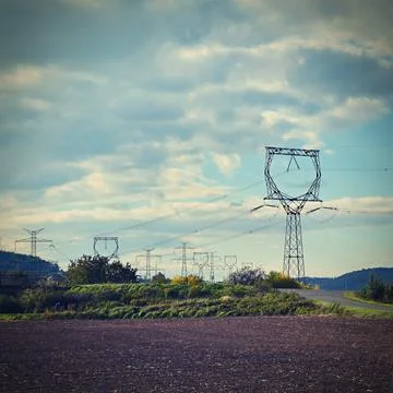 High voltage pylons - Blue sky with clouds and sun in nature. Concept for tec Stock Photos
