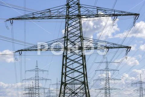 Photograph: High voltage pylons in front of cloudy sky overhead power ...