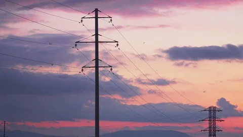 High-voltage support at sunset, the birds fly and sit on them Stock Footage 105534682
