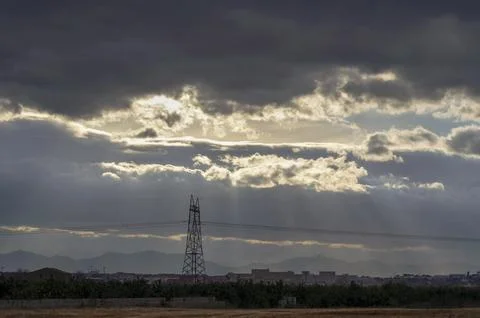High voltage tower covered by black clouds Stock Photos