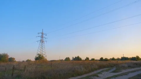 High voltage tower. High-voltage tower in a field against the blue sky. Static Stock-Footage 262770114