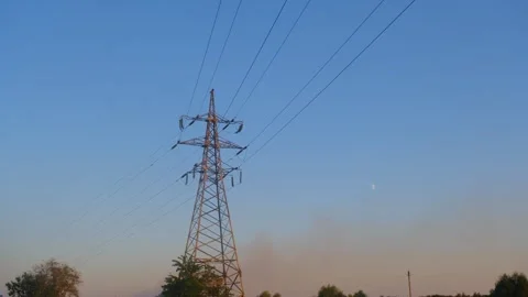 High voltage tower. High-voltage tower in a field against the blue sky. Static Stock-Footage 262770165