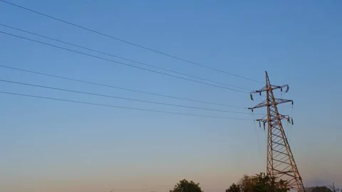 High voltage tower. High-voltage tower in a field against the blue sky. Static Stock-Footage 262770184