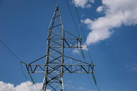 High voltage tower under blue cloudy sky Stock Photos