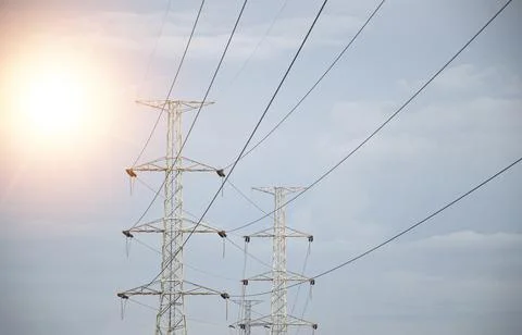 High voltage towers at sunset background. Power lines against the sky Stock Photos