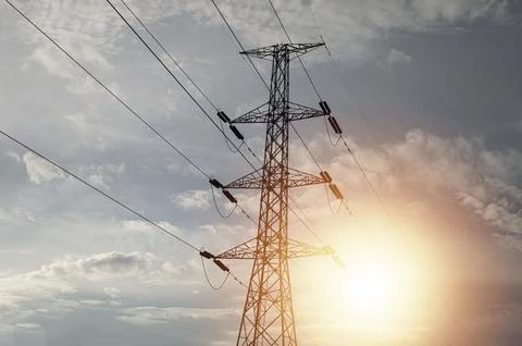 High voltage towers at sunset background. Power lines against the sky Stock Photos