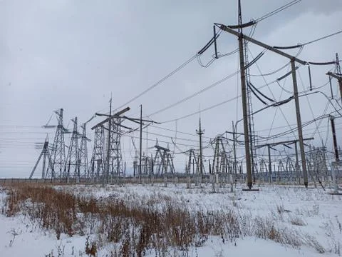 High voltage towers with wires in cloudy snowy weather with clouds in the sky Stock Photos